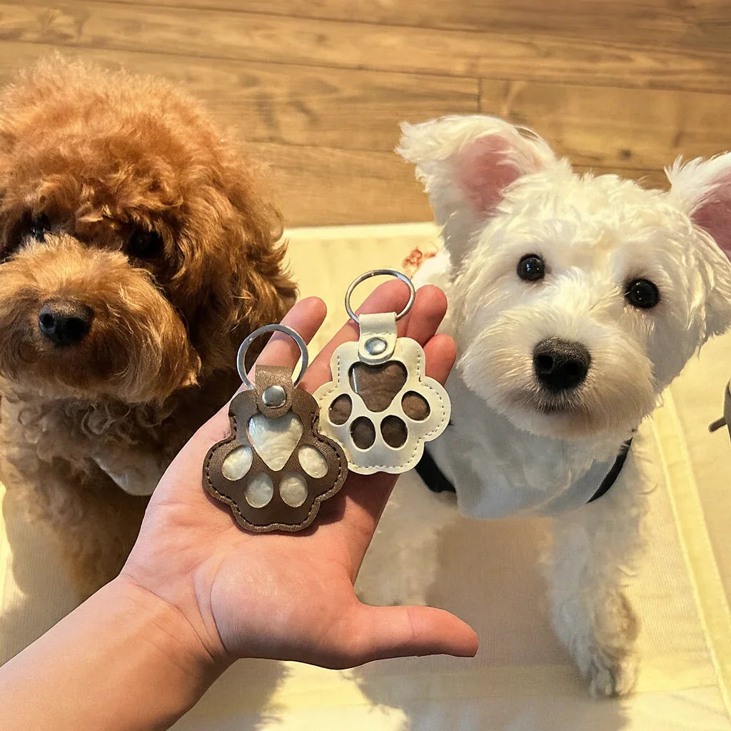 A custom paw-shaped leather pet fur keepsake keychain