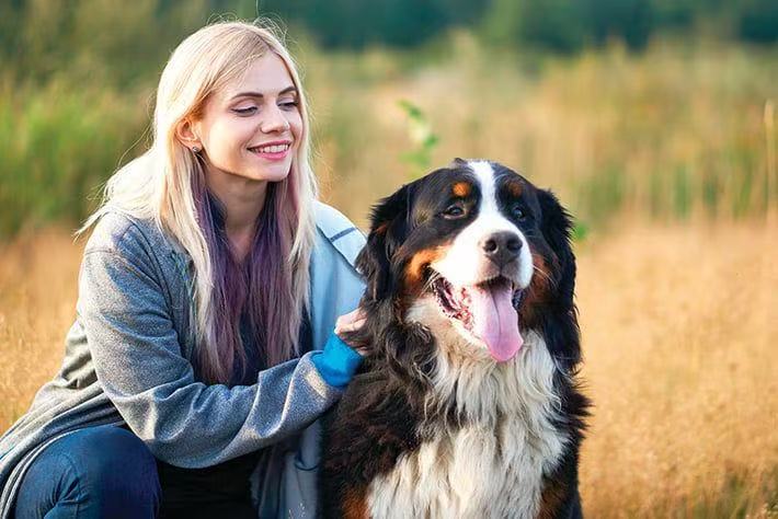 Happy Petailor customer with her Bernese Mountain Dog, loving her personalized pet face portrait necklace. Authentic five-star review.